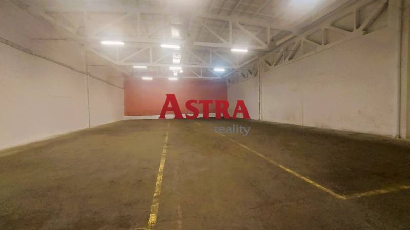 NA PRENÁJOM SKLAD 632 m2, KOŠICE - JUH - Priestor vo vnútri skladu s betónovou podlahou a bielymi oceľovými priehradovými stropmi.