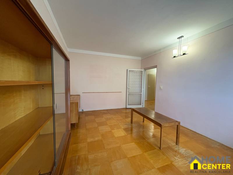 R E Z E R V O V A N Ý 3 izbový byt s balkónom , Košická, Komárno - Obývacia izba v 3-izbovom byte s podlahou s dreveným dekorom a nábytkom.