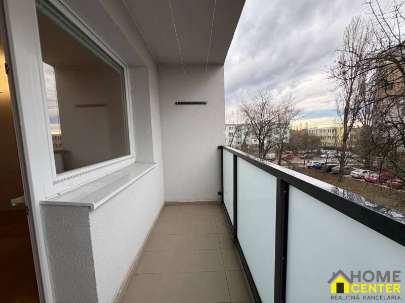 R E Z E R V O V A N Ý 3 izbový byt s balkónom , Košická, Komárno - Balkón 3-izbového bytu v Komárne na Košickej ulici s výhľadom na parkovisko a stromy.