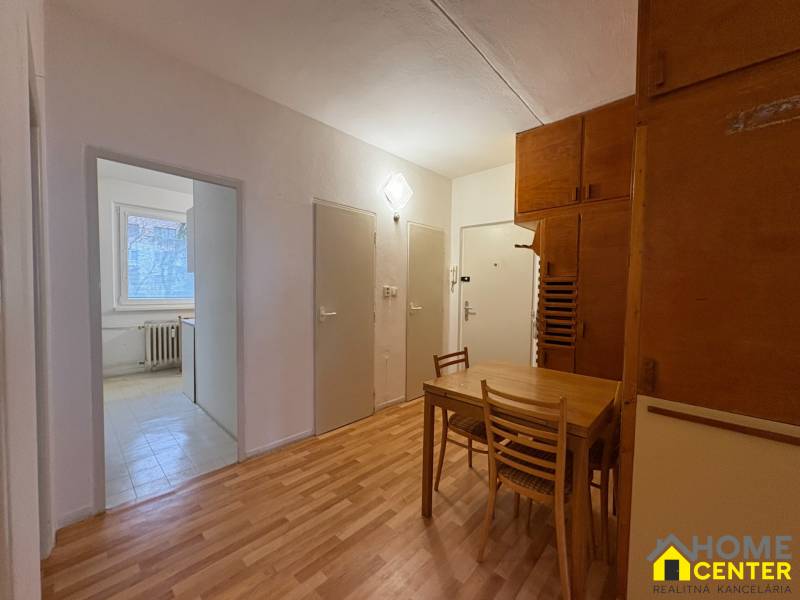 R E Z E R V O V A N Ý 3 izbový byt s balkónom , Košická, Komárno - Interiér 3-izbového bytu s podlahou s dreveným dekorom, jedálenský kút so stolom a stoličkami.