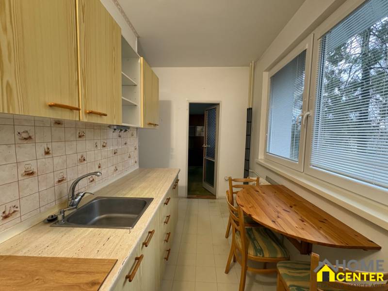 R E Z E R V O V A N Ý 3 izbový byt s balkónom , Košická, Komárno - Kuchyňa v 3-izbovom byte s dreveným dekorom, drevený stôl a kachličkový obklad.