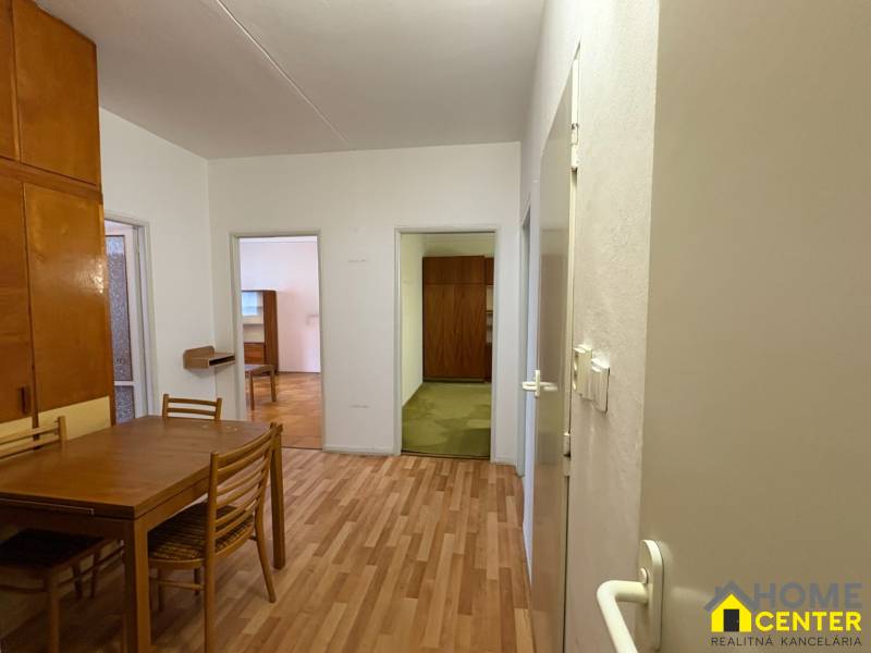 R E Z E R V O V A N Ý 3 izbový byt s balkónom , Košická, Komárno - Interiér 3-izbového bytu s podlahou s dreveným dekorom, stolom a stoličkami.