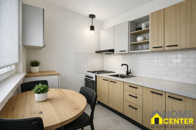 R E Z E R V O V A N Ý 3 izbový byt s balkónom , Košická, Komárno - Kuchyňa v 3-izbovom byte s dreveným dekorom, bielymi kachličkami a okrúhlym stolom.