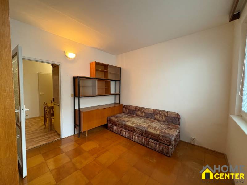 R E Z E R V O V A N Ý 3 izbový byt s balkónom , Košická, Komárno - Izba v 3-izbovom byte s pohovkou, skrinkou a podlahou s dreveným dekorom.