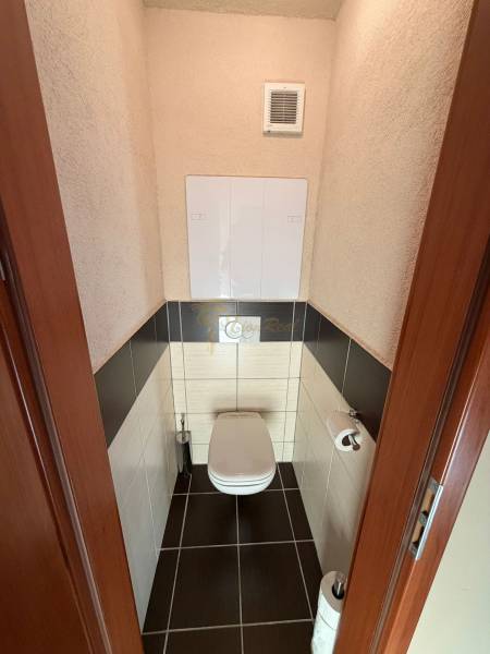 4-izb. byt, Wolkrova, Petržalka, 7.p./8 - Toaleta v 4-izbovom byte s tmavou dlažbou a stenovým ventilátorom.