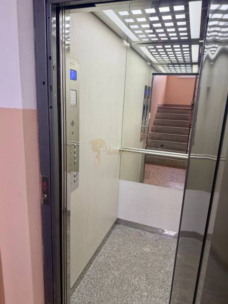 4-izb. byt, Wolkrova, Petržalka, 7.p./8 - Otvorený výťah vo vchode, prepojený so schodiskom a podlahou s dreveným dekorom.