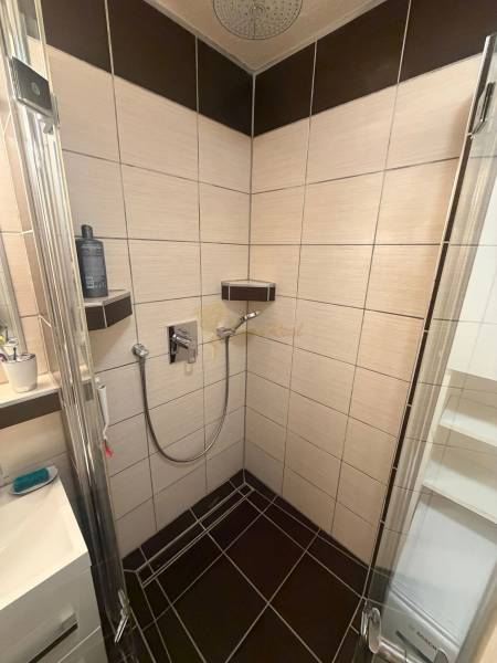 4-izb. byt, Wolkrova, Petržalka, 7.p./8 - Sprchový kút v kúpeľni 4-izbového bytu s obkladom v tmavých a svetlých odtieňoch.