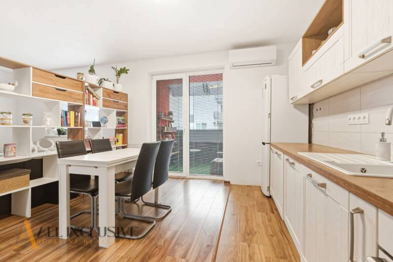 Na predaj moderný 2-izb. byt s loggiou vo Vrábľoch - Kuchyňa v 2-izbovom byte s jedálenským stolom a podlahou s dreveným dekorom.