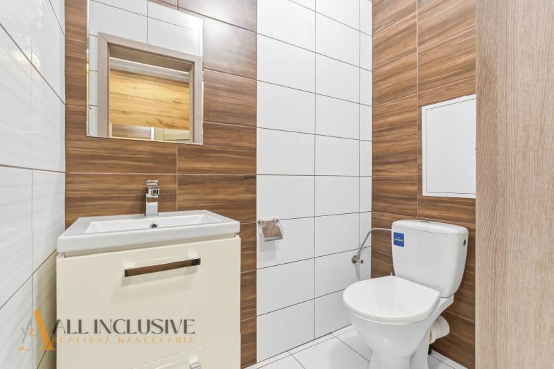 Na predaj moderný 2-izb. byt s loggiou vo Vrábľoch - Kúpeľňa v 2-izbovom byte s toaletou, umývadlom a obkladmi s dreveným dekorom.