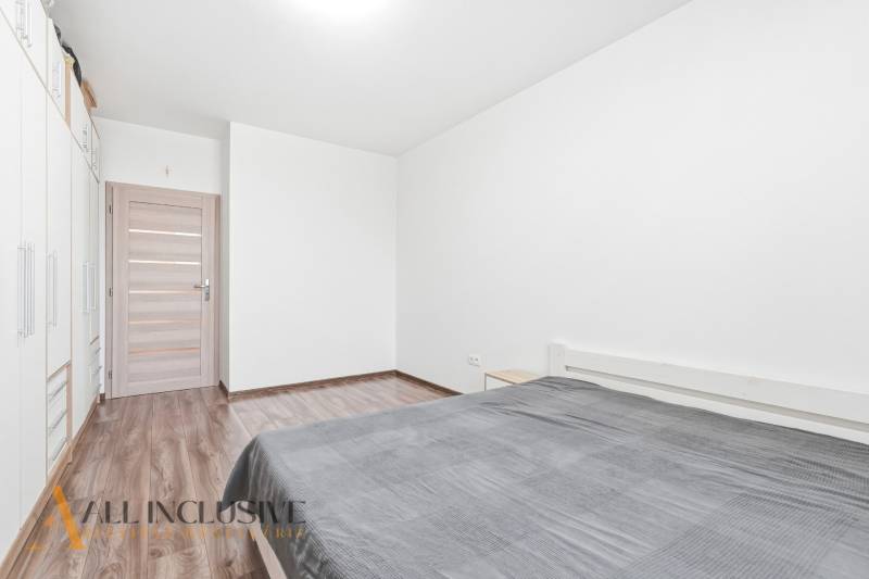 Na predaj moderný 2-izb. byt s loggiou vo Vrábľoch - Spálňa v 2-izbovom byte s podlahou s dreveným dekorom a priestrannou skriňou.