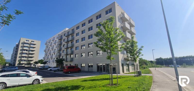 Zariadený 2-izb. byt v novostavbe v Ružinove - Ovocné sady - Bytové domy s balkónmi, stromy a zaparkované autá na ivanskej ceste, Bratislava - Ružinov.