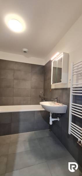 Zariadený 2-izb. byt v novostavbe v Ružinove - Ovocné sady - Kúpeľňa v 2-izbovom byte s vaňou, umývadlom a zrkadlovou skrinkou.