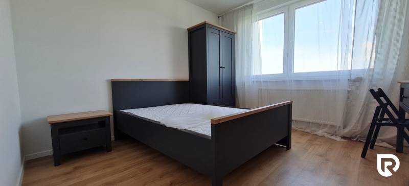 Zariadený 2-izb. byt v novostavbe v Ružinove - Ovocné sady - Spálňa s posteľou, šatníkom a podlahou s dreveným dekorom v 2-izbovom byte.