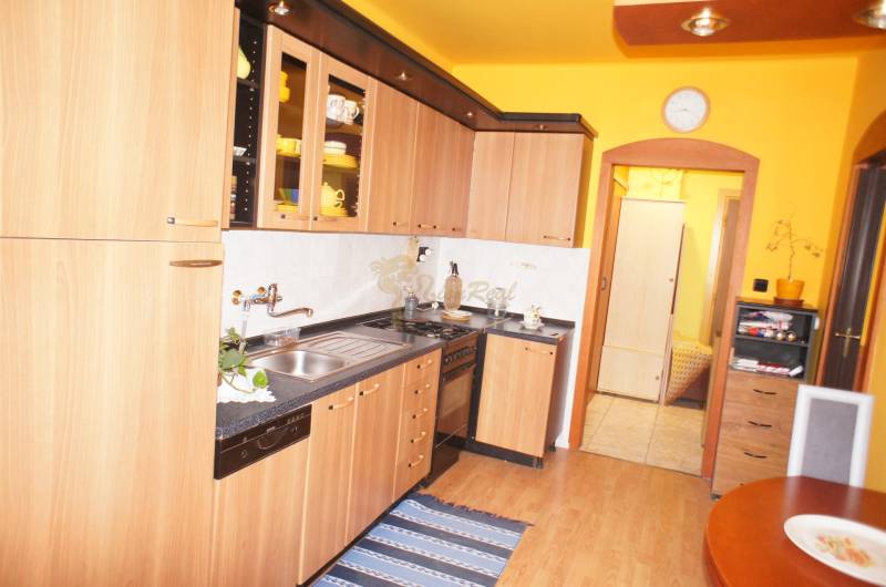 Veľký 1-izb. byt v tehlovom dome, Miletičova ul., Ružinov  - Kuchyňa v 1-izbovom byte so svetlým nábytkom a podlahou s dreveným dekorom.