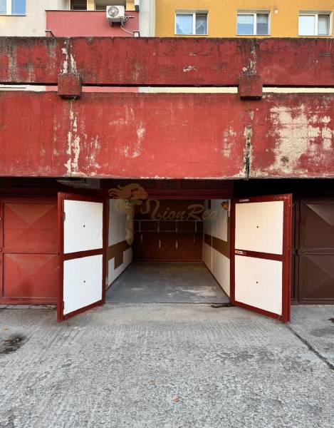 Garáž Bebravská ul., Vrakuňa s pozemkom - Garáže na Bebravskej ulici v Bratislave - Vrakuni s otvorenými kovovými bránami.