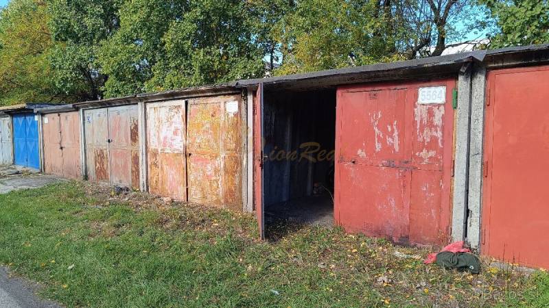 Garáž, Agátova, Dúbravka s pozemkom - Garáže na Agátovej ulici v Bratislave-Dúbravke obklopené zeleňou a lístím.