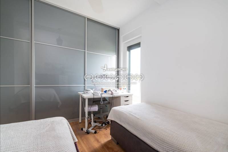 ZATON - Apartmán so záhradou - na predaj  - Spálňa v Rekreačnom apartmáne s posuvnou skriňou a posteľou, podlaha s dreveným dekorom.