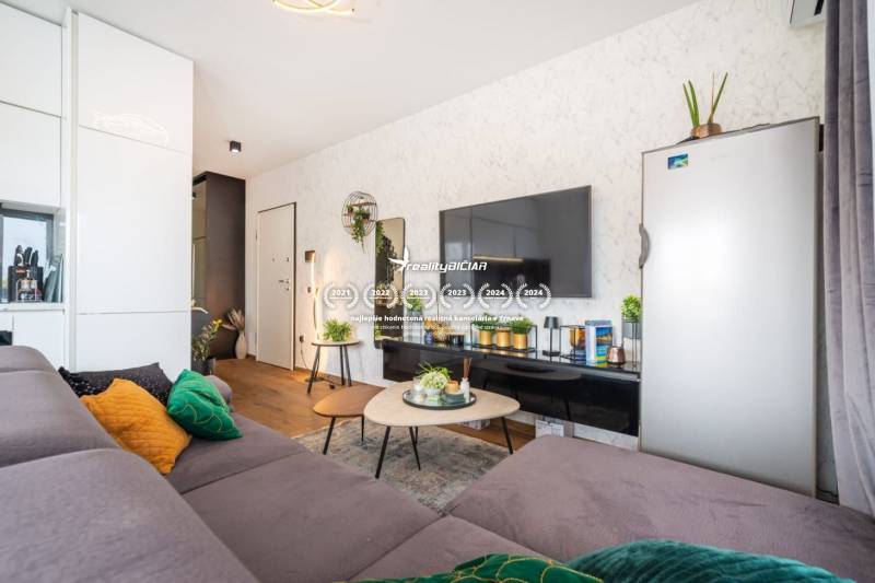 ZATON - Apartmán so záhradou - na predaj  - Štýlový interiér rekreačného apartmánu s pohovkou, stolíkom a podlahou s dreveným dekorom.