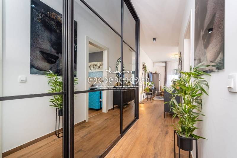 ZATON - Apartmán so záhradou - na predaj  - Interiér rekreačného apartmánu s podlahou s dreveným dekorom, zrkadlovou stenou a rastlinami.