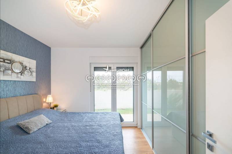 ZATON - Apartmán so záhradou - na predaj  - Spálňa v Rekreačnom apartmáne s podlahou s dreveným dekorom a veľkým šatníkom.