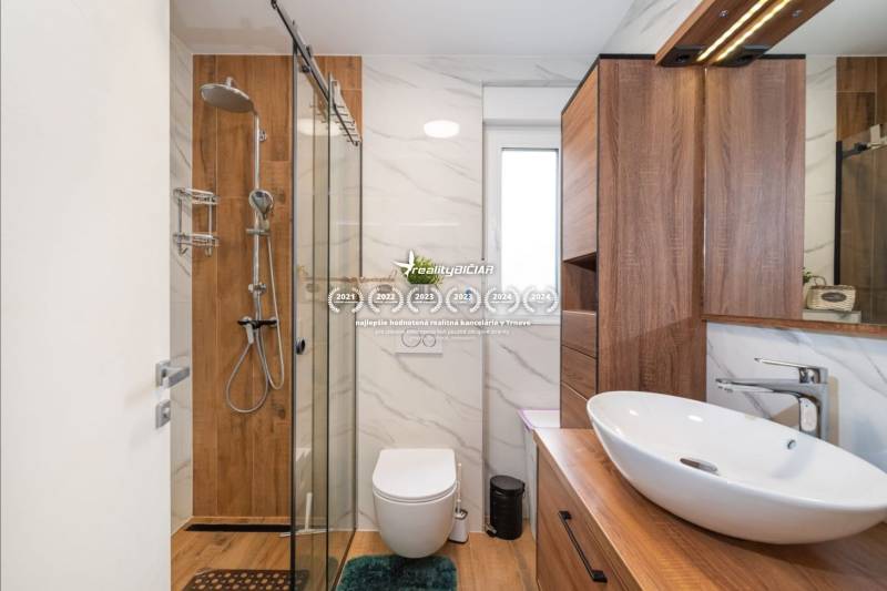 ZATON - Apartmán so záhradou - na predaj  - Kúpeľňa v rekreačnom apartmáne s podlahou s dreveným dekorom a moderným vybavením.