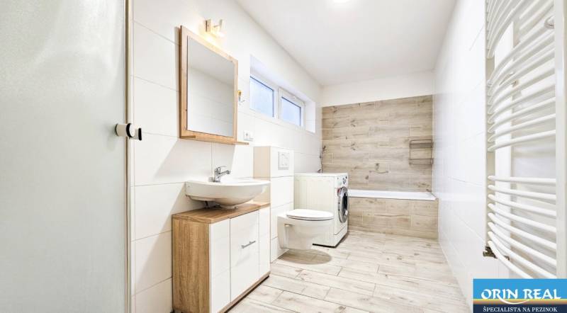 Na predaj kompletne zrekonštruovaný RD Bernolákovo -Trnavská - Kúpeľňa v rodinnom dome s podlahou s dreveným dekorom a práčkou.