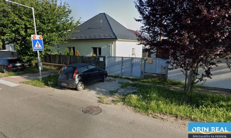 Na predaj kompletne zrekonštruovaný RD Bernolákovo -Trnavská - Rodinný dom na Trnavskej ulici v Bernolákove s autom zaparkovaným pred bránou.