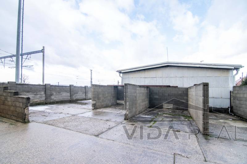 Prenájom haly / obchodno-skladových priestorov – Šenkvice, Nádražná ul - V Šenkviciach na Nádražnej ulici sú na fotografii zobrazené sklady a haly s pevnými betonovými stenami.