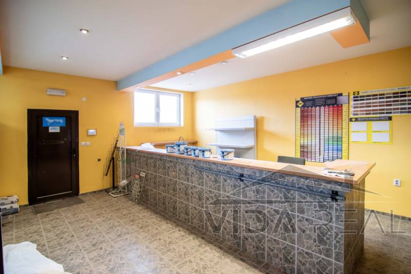 Prenájom haly / obchodno-skladových priestorov – Šenkvice, Nádražná ul - Interiér predajne v skladoch a halách s pultom, poličkami a farebnými vzorkami na stene.