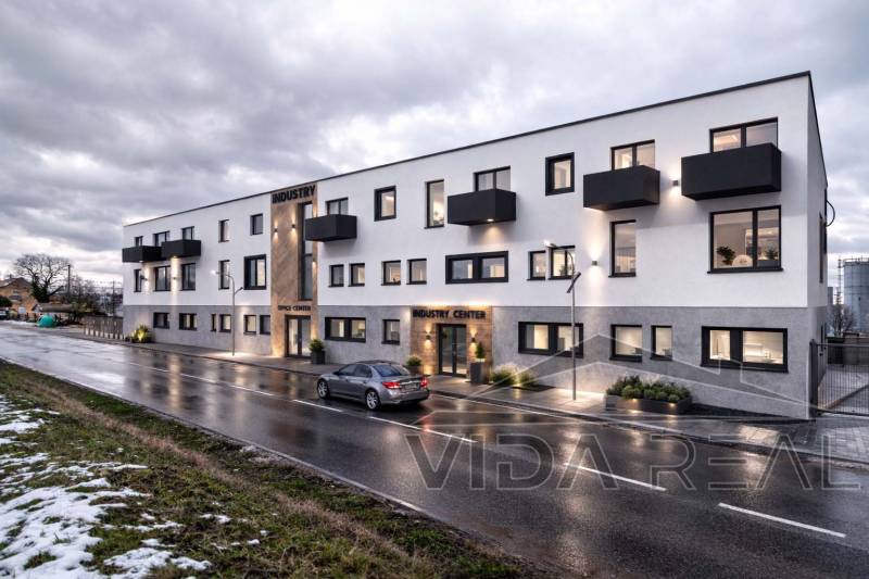 Prenájom haly / obchodno-skladových priestorov – Šenkvice, Nádražná ul - Budova na Nádražnej ulici v Šenkviciach, Sklady a haly, s večerným osvetlením.