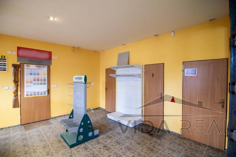 Prenájom haly / obchodno-skladových priestorov – Šenkvice, Nádražná ul - Priestor so žltými stenami a kovovými stojanmi v Skladoch a halách.