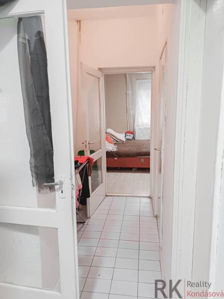 Rodinný dom, Maďarsko, obec Vizsoly - Úzky biely chodba vedie k detskej izbe s posteľou v rodinnom dome.