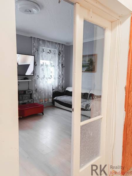 Rodinný dom, Maďarsko, obec Vizsoly - Obývačka v rodinnom dome s televízorom a podlahou s dreveným dekorom.