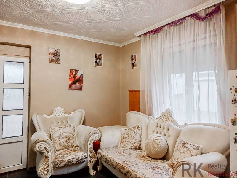 Rodinný dom, Maďarsko, obec Vizsoly - Obývacia izba rodinného domu s ornamentálnym nábytkom a fotografiami na stenách.