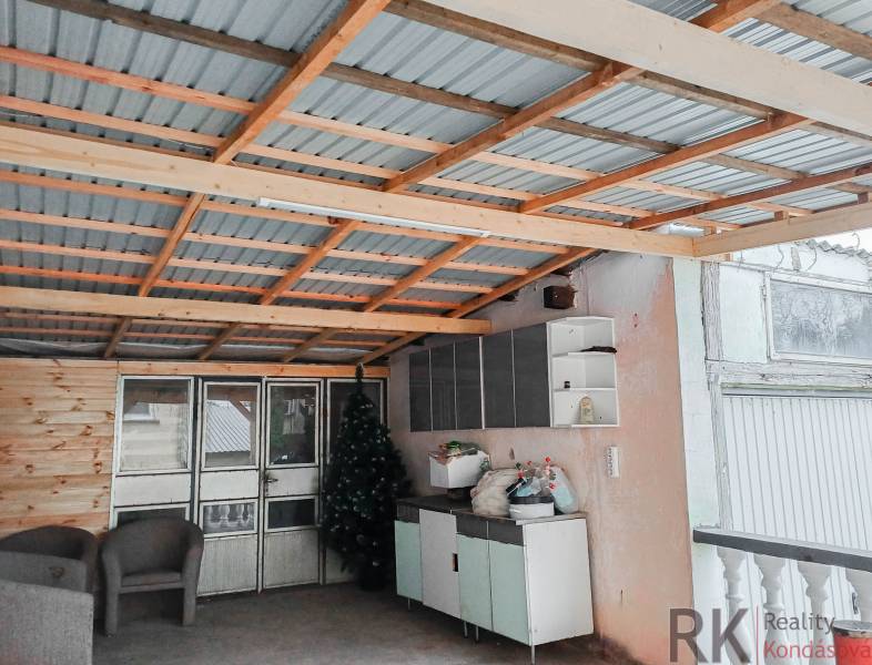 Rodinný dom, Maďarsko, obec Vizsoly - Rodinný dom: Prístrešok s kovovou strechou, ratanové kreslá, umelé stromčeky, úložné priestory.