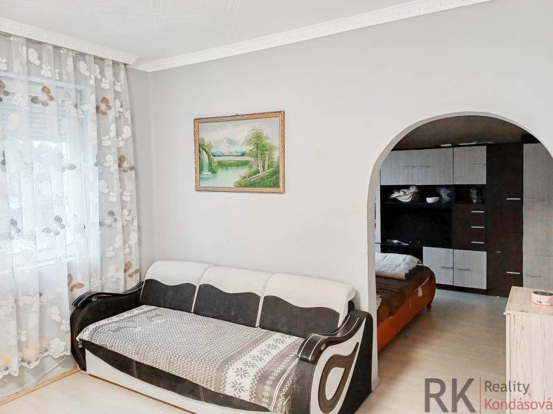 Rodinný dom, Maďarsko, obec Vizsoly - Svetlá obývacia izba s pohovkou, veľkým oblúkovým priechodom a závesmi s kvetinovým vzorom.