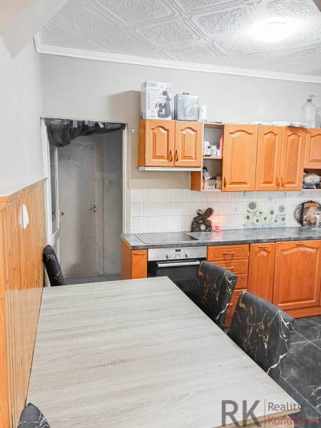 Rodinný dom, Maďarsko, obec Vizsoly - Kuchyňa v rodinnom dome s drevenými skrinkami a stropným obkladom.