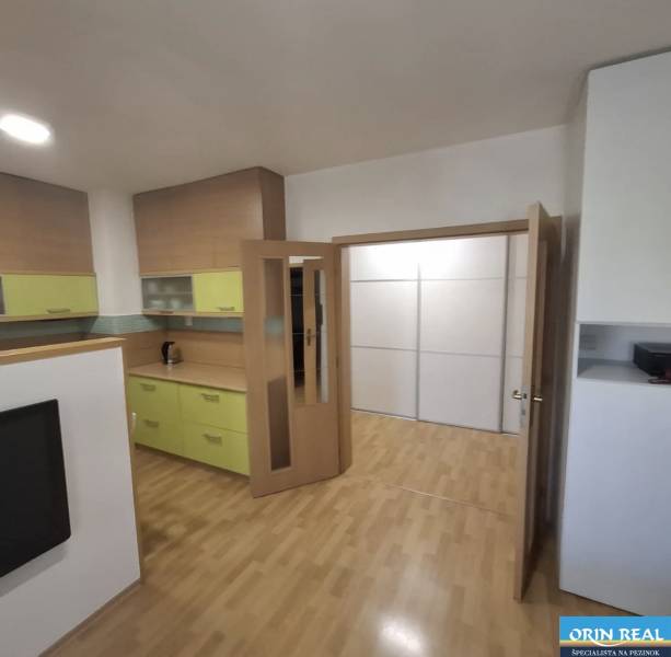 Na prenájom klimatizovaný 2 izbový byt v Moste pri Bratislave - Interiér 2-izbového bytu s podlahou s dreveným dekorom a svetlým nábytkom.