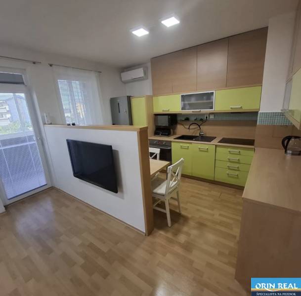 Na prenájom klimatizovaný 2 izbový byt v Moste pri Bratislave - Kuchyňa v 2-izbovom byte s podlahou s dreveným dekorom a svetlou linkou.