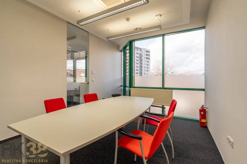 Reprezentatívne administratívne priestory na prenájom  - Kancelárie so sklenenou stenou, bielym stolom a červenými stoličkami.