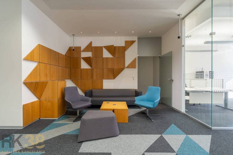 Reprezentatívne administratívne priestory na prenájom  - Interiér kancelárií s farebným sedením, sklom a geometrickými drevenými panelmi.