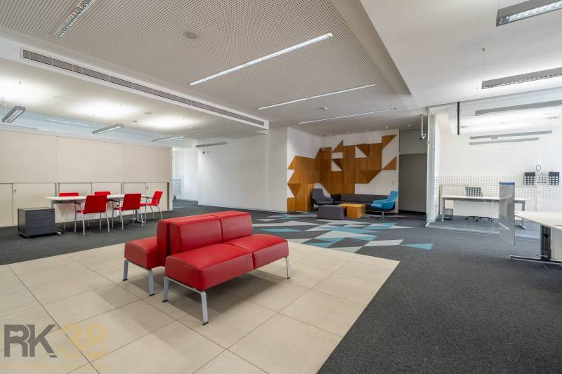 Reprezentatívne administratívne priestory na prenájom  - Kancelárie s červenými sedačkami, konferenčným stolom, vzorovaným kobercom a drevenými dekoráciami.