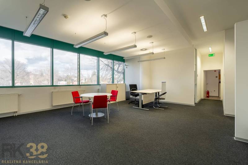 Reprezentatívne administratívne priestory na prenájom  - Kancelárie s čiernym kobercom, červenými stoličkami a veľkými oknami na prízemí.