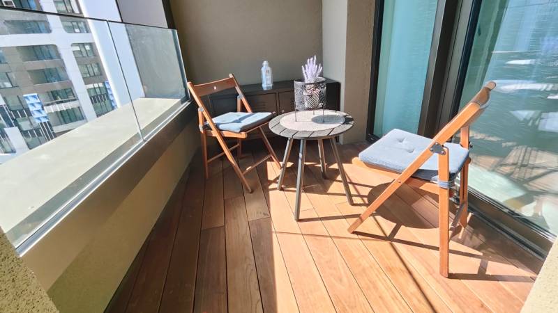 NUERA︱SKY PARK Moderný 2-izbový byt na 6. poschodí, veža 3 - Balkón s podlahou s dreveným dekorom, posedenie a okrasný stôl v 2-izbovom byte.