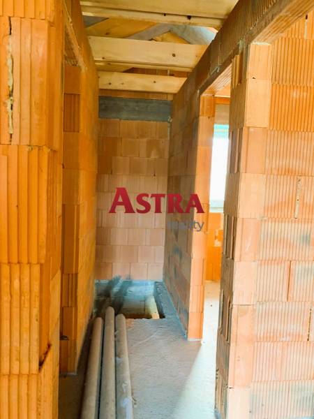 CHATA UZAVRETÁ HRUBÁ STAVBA, KOŠICKÁ NOVÁ VES - GEDER - Interiér s murovanými stenami, dreveným stropom a položenými rúrkami v novej chate.