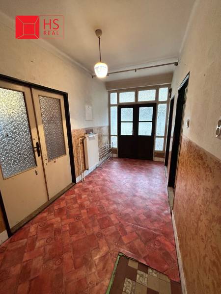 Predaj staršieho RD vo Dvoroch nad Žitavou - Chodba v Rodinnom dome s farebnou podlahou a veľkými presklenými dverami.