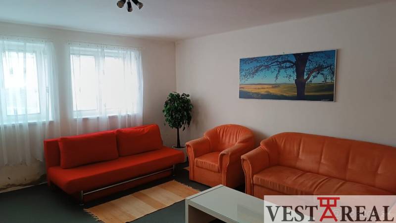 Na Predaj Rodinný dom pozemok 1587 m² v Horných Salibách  - Obývacia izba v rodinnom dome s oranžovou sedačkou, kreslami a obrazom krajiny.