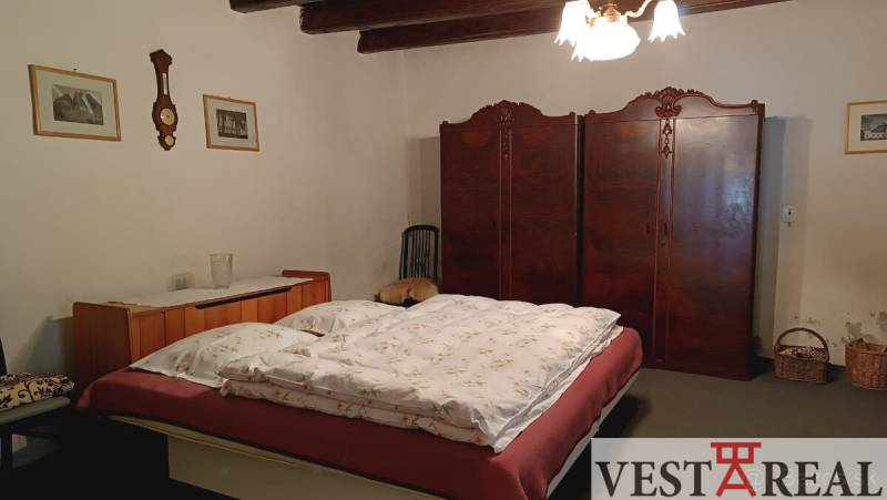 Na Predaj Rodinný dom pozemok 1587 m² v Horných Salibách  - Spálňa v rodinnom dome s posteľou, vstavanou skriňou a vidieckym dekorom.