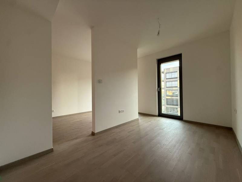 NUERA︱METROPOLIS - 1,5 izbový BYT (nie apartmán) v Starom Meste - Izba v 2-izbovom byte s podlahou s dreveným dekorom a balkónovými dverami.