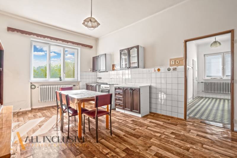 REZERVOVANÉ 3-IZBOVÝ RD NA PRIESTRANNOM POZEMKU, VRAKÚ - Kuchyňa v rodinnom dome s podlahou s dreveným dekorom, jedálenským stolom a stoličkami.